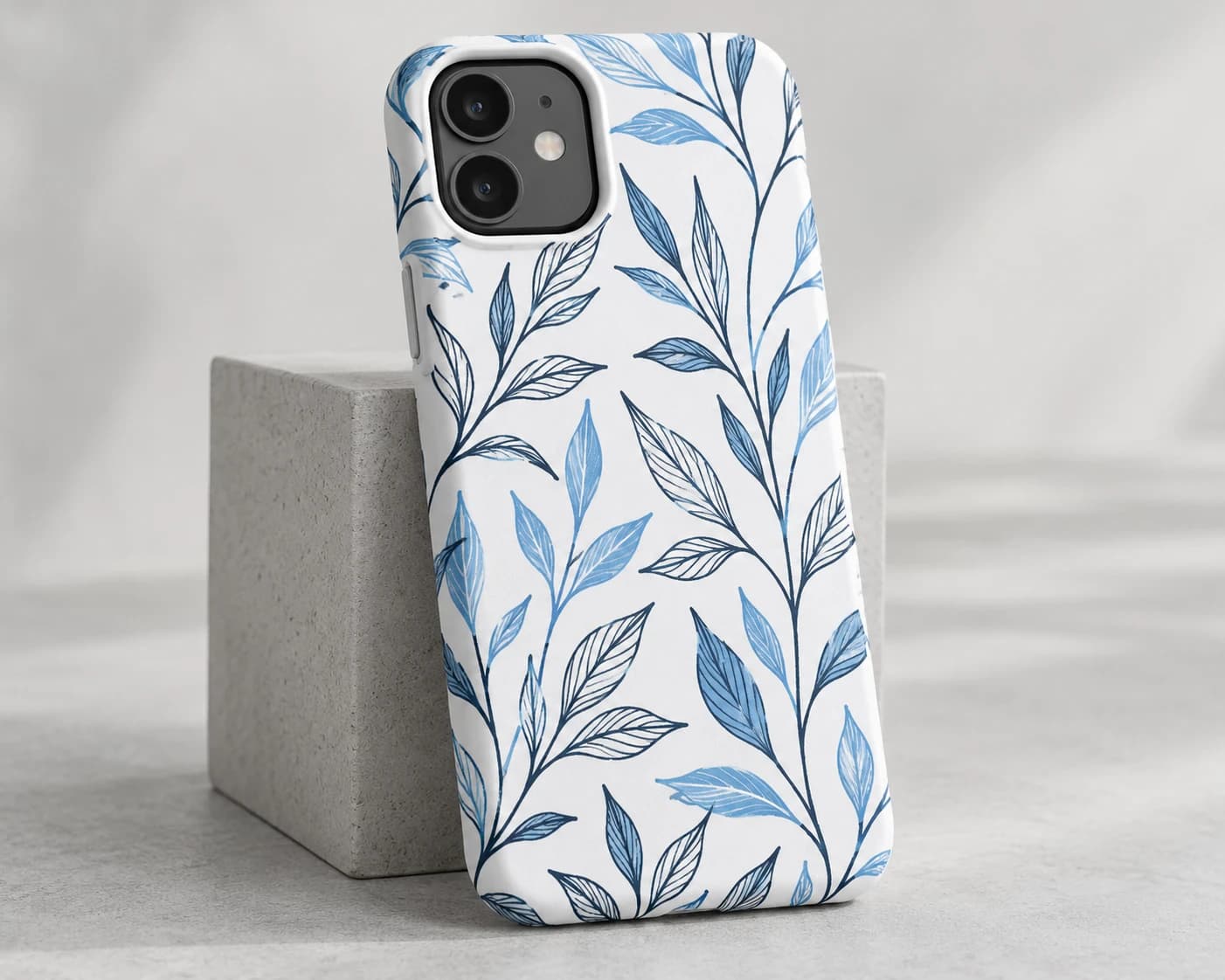 White phone case printed edge to edge with a blue botanical line pattern
